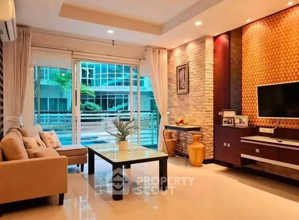 Modern living room with stylish decor and large windows overlooking a balcony.