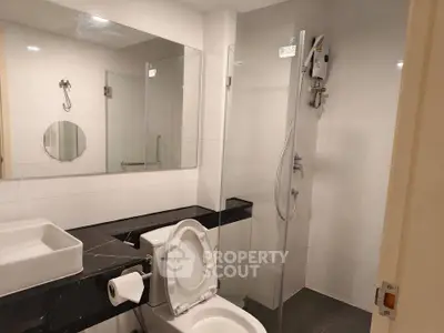 Modern bathroom with sleek design featuring glass shower and stylish fixtures.