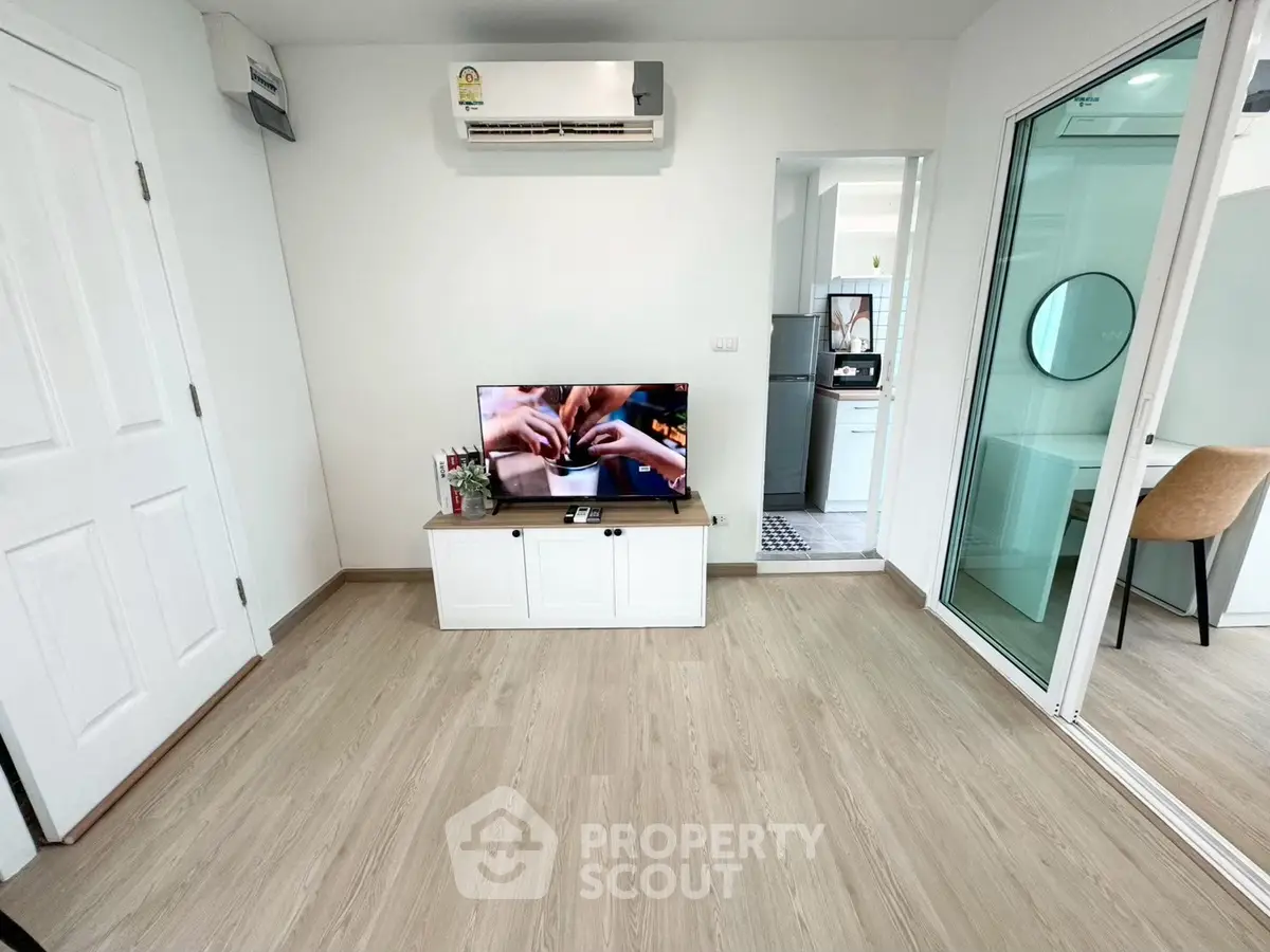 Modern living room with sleek wooden flooring and wall-mounted air conditioner, featuring a TV and stylish decor.