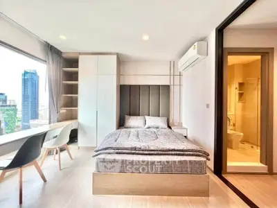 Modern bedroom with city view, featuring sleek furniture and ensuite bathroom.