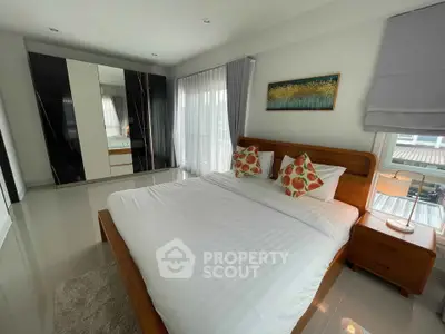 Spacious modern bedroom with elegant decor and large windows for natural light.