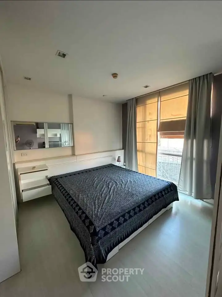 Spacious bedroom with large windows and modern decor in a stylish apartment.