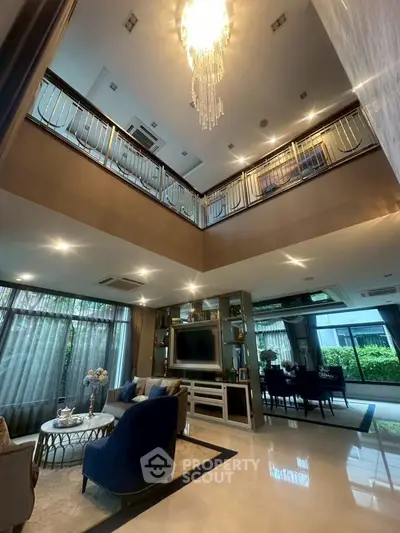 Luxurious double-height living room with elegant chandelier and modern decor