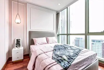 Luxurious bedroom with floor-to-ceiling windows and elegant decor in modern apartment.