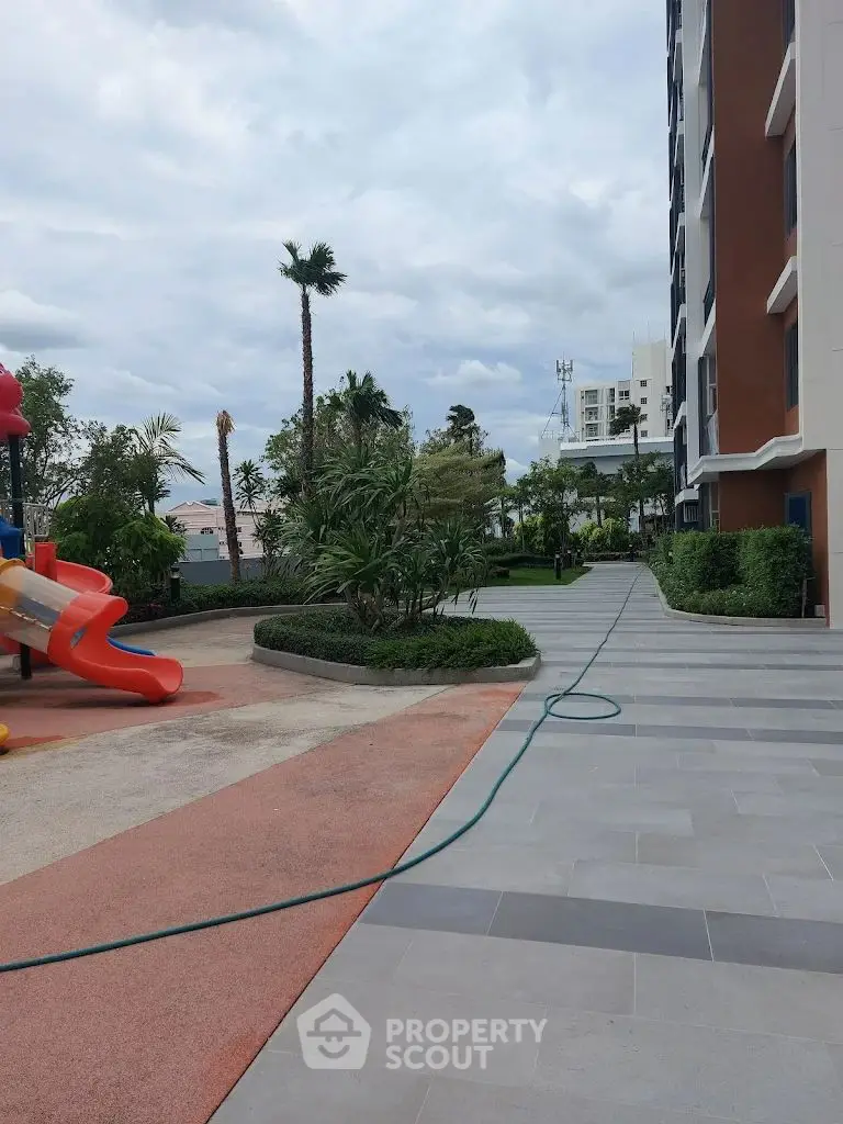 Modern apartment building with landscaped garden and playground area.