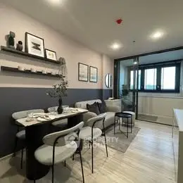 Modern living room with stylish decor and dining area in open layout apartment.