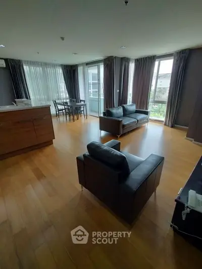 Spacious modern living room with hardwood floors and large windows