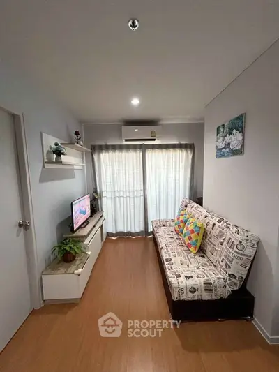 Cozy living room with modern decor and natural light, featuring a stylish sofa and entertainment unit.