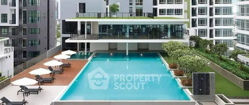 Luxurious modern apartment complex with stunning rooftop pool and lush greenery.