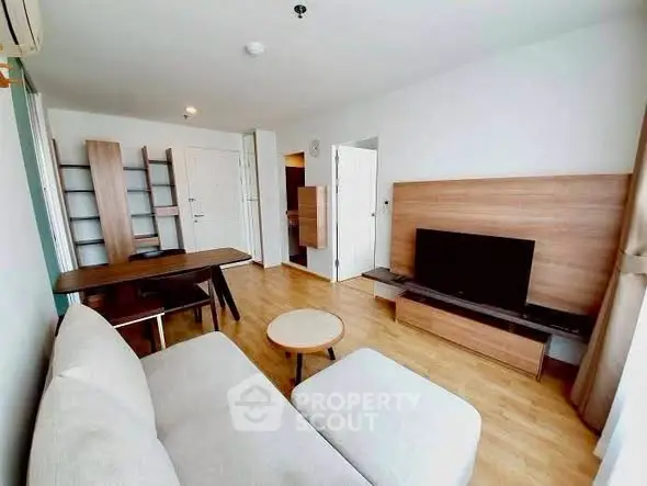 Modern living room with stylish furniture and wooden flooring in a bright apartment.
