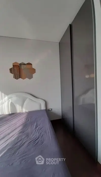 Modern bedroom with sleek wardrobe and stylish wall decor