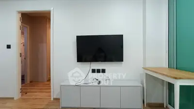 Modern living room with wall-mounted TV and sleek cabinet