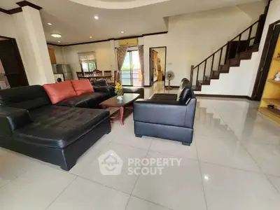 Spacious living room with modern black leather furniture and open layout