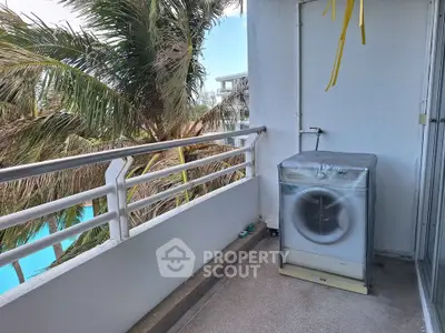 Charming balcony with washing machine and tropical view, perfect for convenient outdoor laundry.