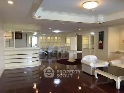 Spacious living room with elegant white furniture and polished wooden floors