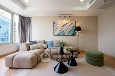 Modern living room with stylish furniture and large windows offering city views.
