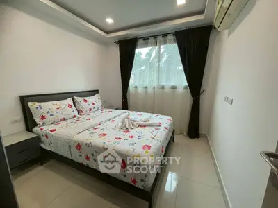 Cozy bedroom with floral bedding and natural light, perfect for relaxation.