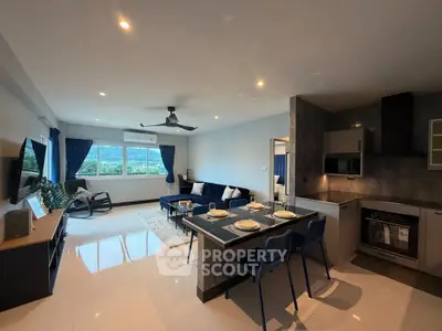 Spacious modern living room with open kitchen and scenic view