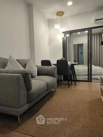 Modern living room with cozy gray sofa and elegant dining area