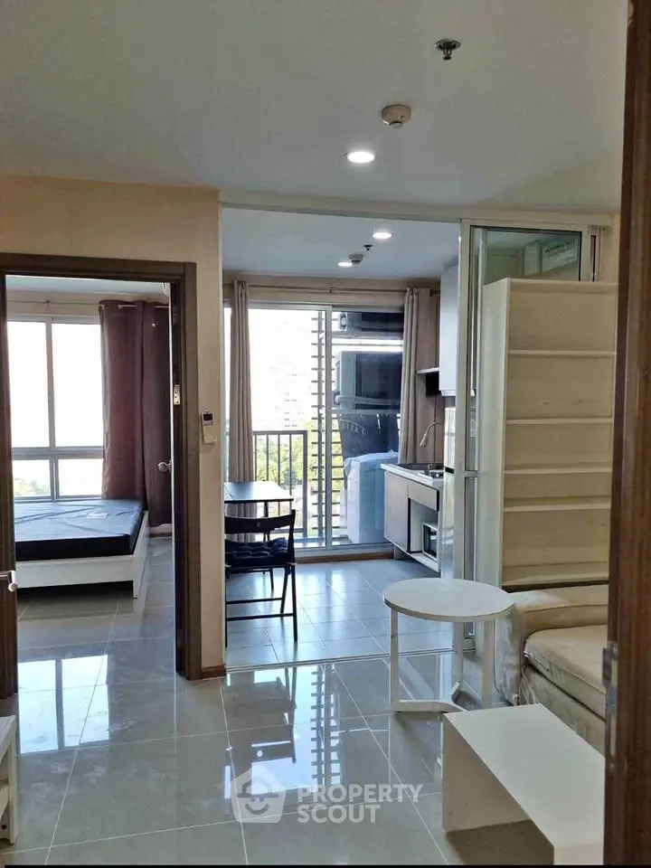 Modern apartment interior with open layout, featuring a cozy living area, compact kitchen, and bright bedroom.