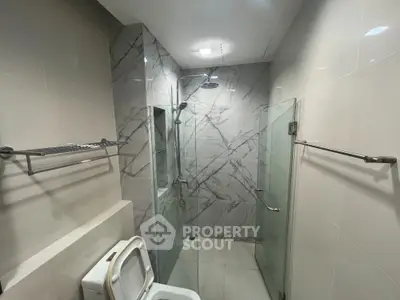 Modern bathroom with glass shower and marble tiles