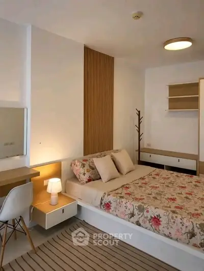 Cozy bedroom with modern decor and floral bedding in a stylish apartment.