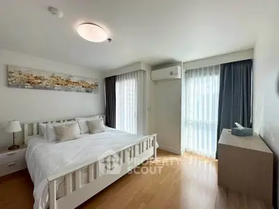Spacious bedroom with modern decor and natural light in a stylish apartment.