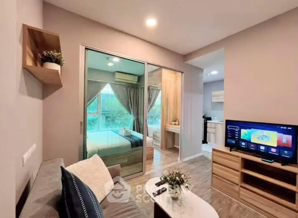 Modern living room with cozy decor and view into bedroom, featuring stylish furniture and ambient lighting.