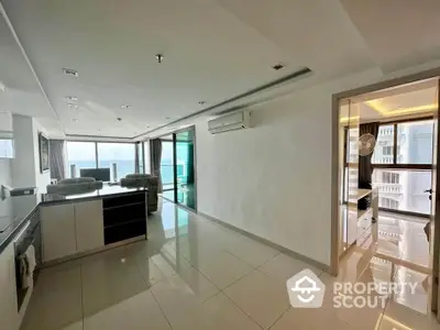 Spacious modern living room with open kitchen and large windows offering stunning views.