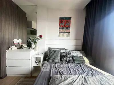 Cozy bedroom with stylish decor and ample natural light, featuring a comfortable bed and modern furnishings.