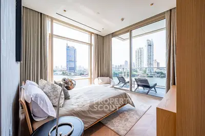 Luxurious bedroom with stunning city view and spacious balcony in modern apartment.