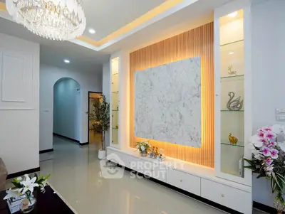 Elegant living room with modern decor and ambient lighting, featuring a marble accent wall and stylish chandelier.