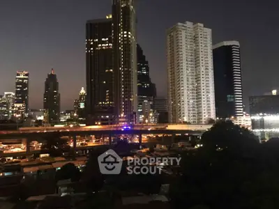 Stunning cityscape view of illuminated skyscrapers at night, showcasing urban living and vibrant city life.