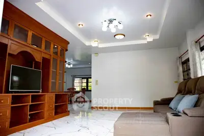 Spacious living room with elegant wooden entertainment center and modern lighting