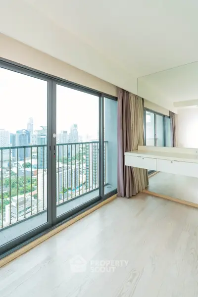 Spacious apartment with floor-to-ceiling windows offering stunning city views and abundant natural light.