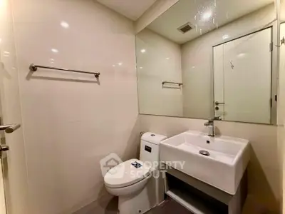 Modern bathroom with sleek fixtures and large mirror in a contemporary apartment.