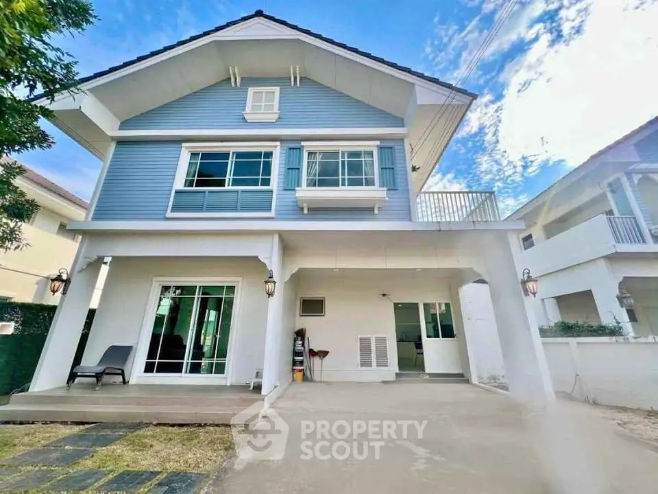 Charming two-story blue house with spacious driveway and modern design in a serene neighborhood.