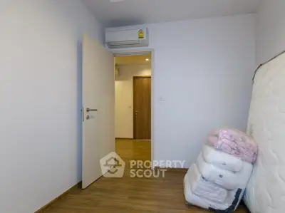 Minimalist bedroom with wooden flooring and air conditioning unit