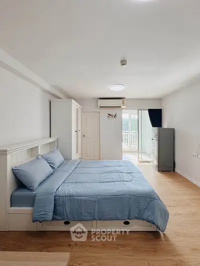 Spacious bedroom with modern decor and balcony access in a stylish apartment.