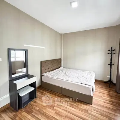 Spacious bedroom with modern decor and wooden flooring