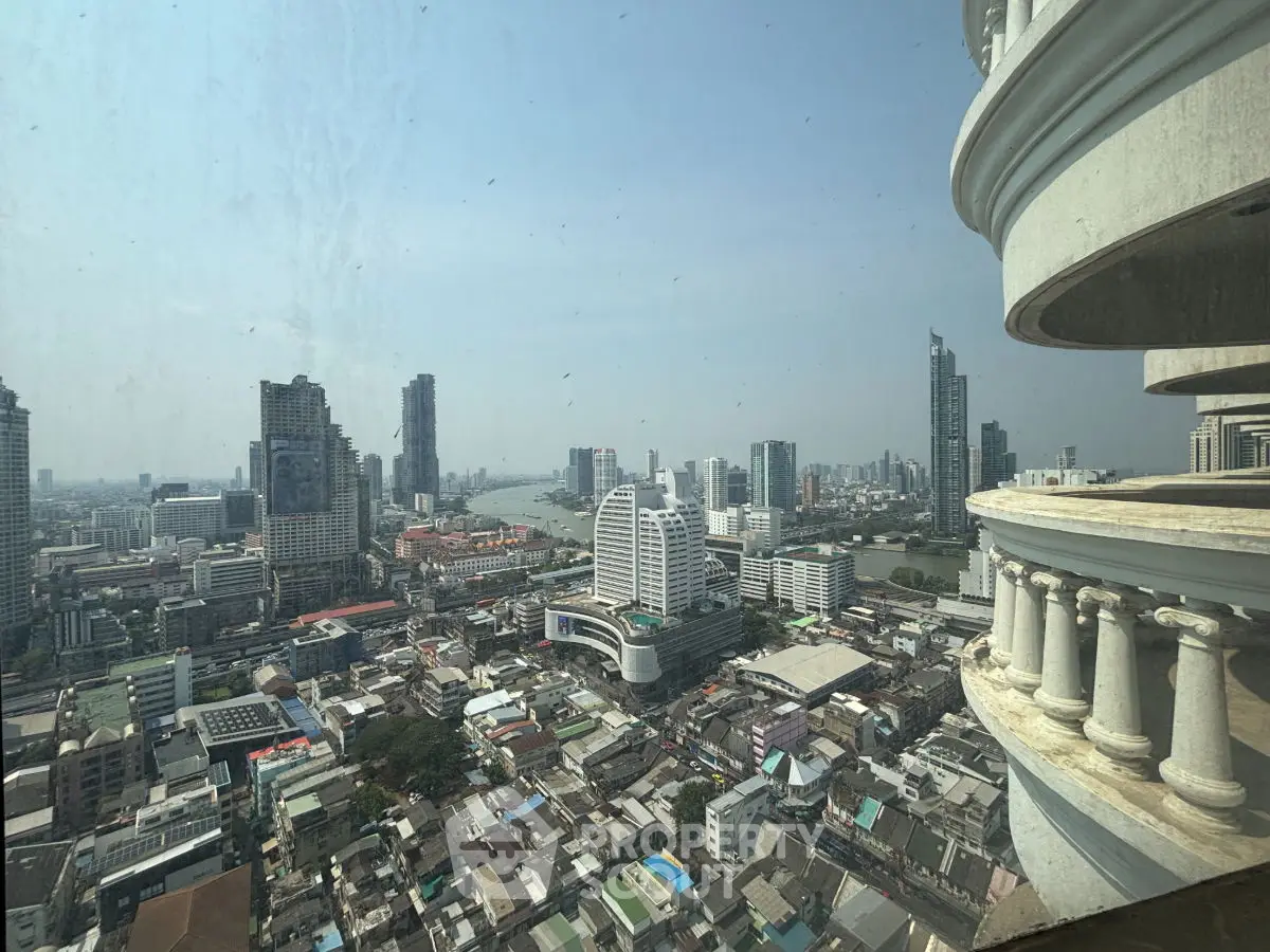 Stunning cityscape view from high-rise balcony overlooking urban skyline and river.