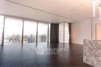 Spacious modern living room with panoramic city views and elegant marble accents.