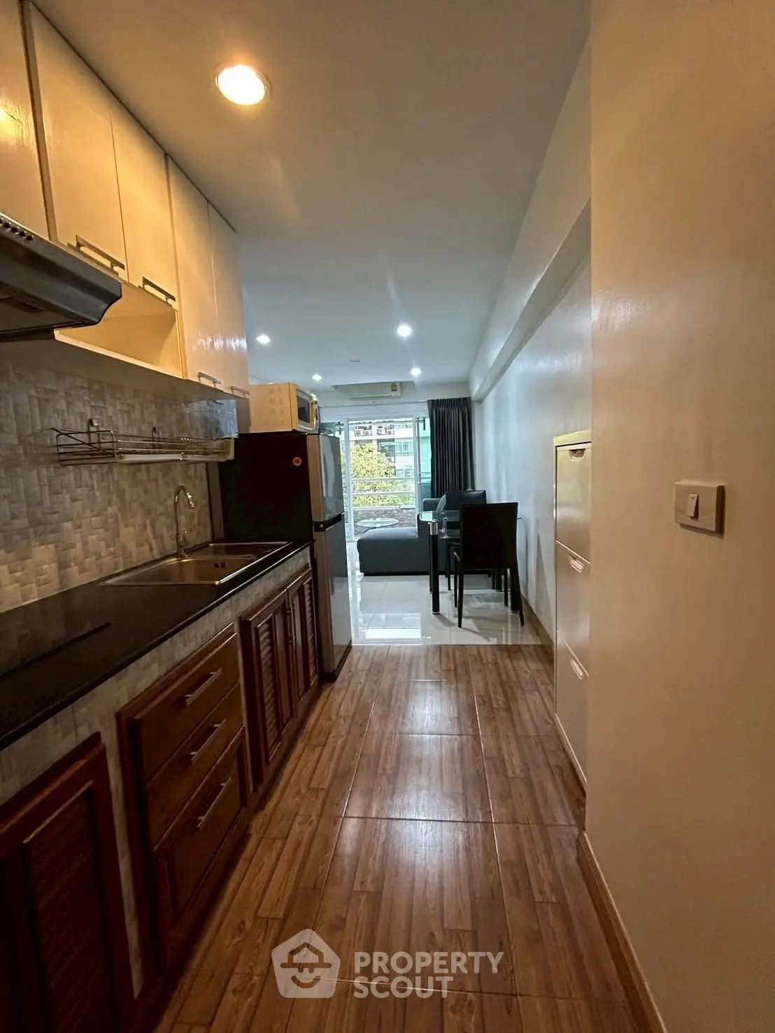 Modern kitchen with open layout leading to cozy living area and dining space.