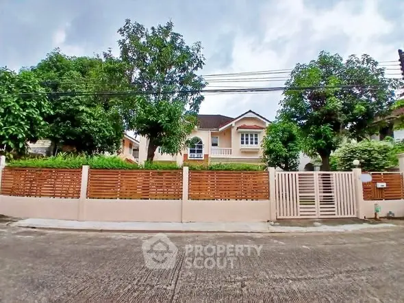 Charming suburban house with lush greenery and modern fence