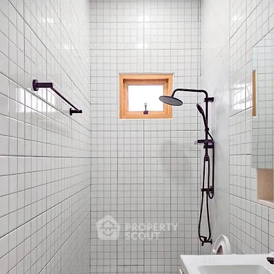 Modern minimalist bathroom with sleek shower and white tiled walls.