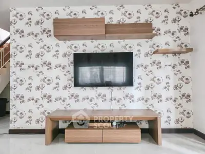 Modern living room with stylish floral wallpaper and mounted TV