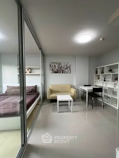 Modern studio apartment with glass partition, cozy living area, and stylish decor.