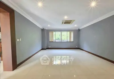 Spacious empty living room with large window and glossy tiled floor.