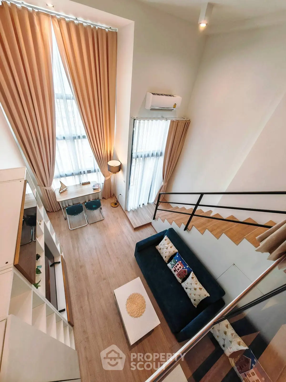 Modern loft-style living room with high ceilings and elegant decor.