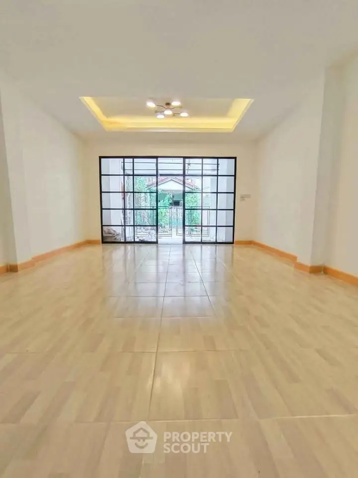 Spacious living room with large windows and elegant lighting